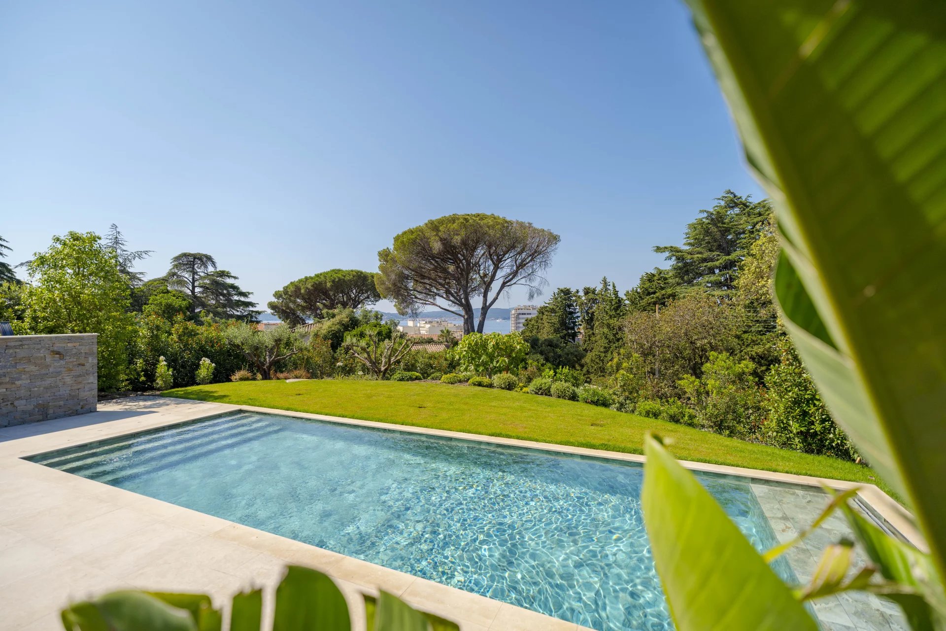 Villa neuve avec piscine à Sainte-Maxime Vue de la piscine et du jardin d'une villa neuve à Sainte-Maxime avec vue sur la mer.