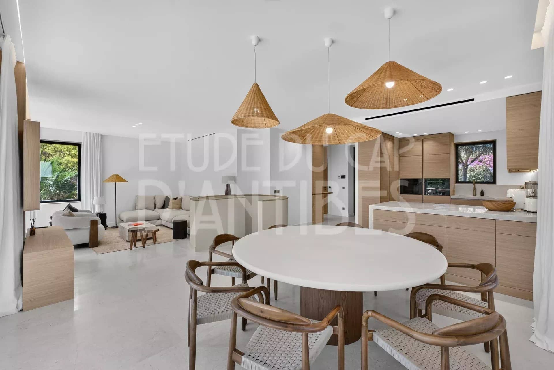Intérieur d'une villa moderne à Antibes avec salon, salle à manger et cuisine ouverte.