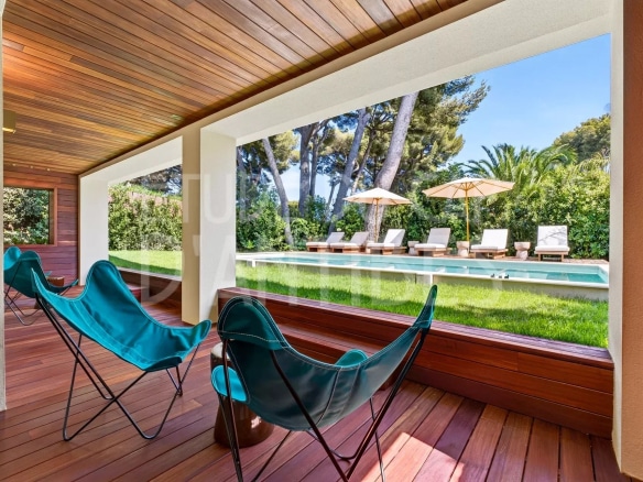 Terrasse d'une villa à Antibes avec vue sur la piscine et le jardin.