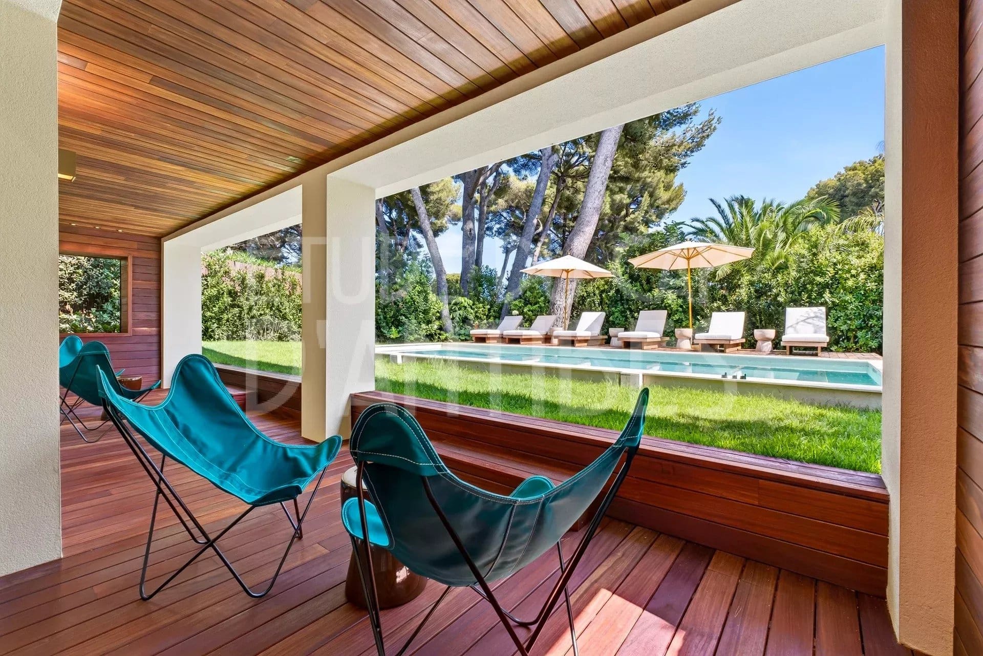 Terrasse d'une villa à Antibes avec vue sur la piscine et le jardin.