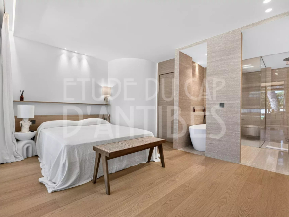 Chambre d'une villa moderne avec salle de bain attenante, décoration épurée et lumière naturelle.