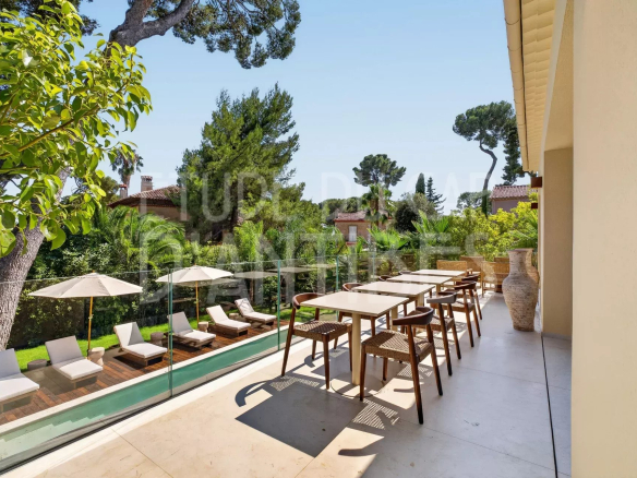 Terrasse d'une villa à Cap d'Antibes avec piscine et chaises longues.