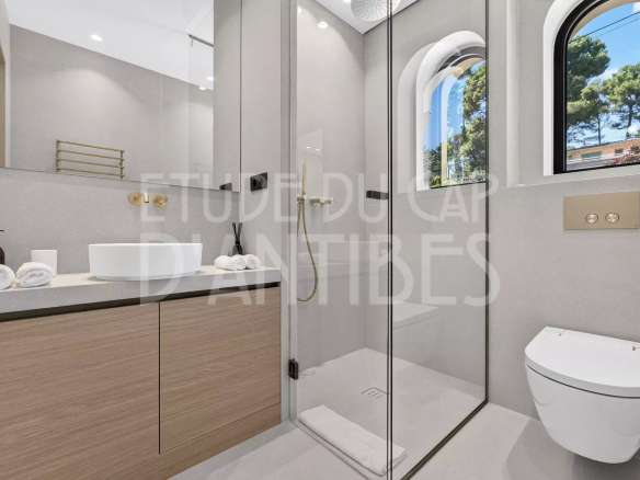 Salle de bain moderne avec douche, lavabo et toilettes dans une villa à Antibes.