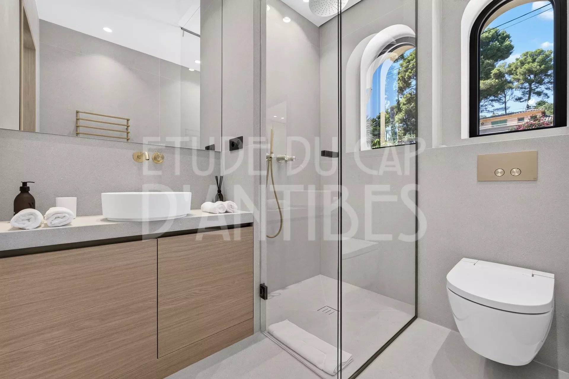 Salle de bain moderne avec douche, lavabo et toilettes dans une villa à Antibes.