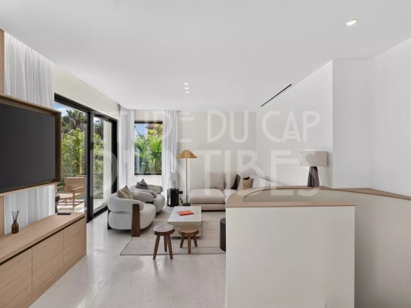 Intérieur d'une villa moderne à Antibes avec salon lumineux et accès à la terrasse.