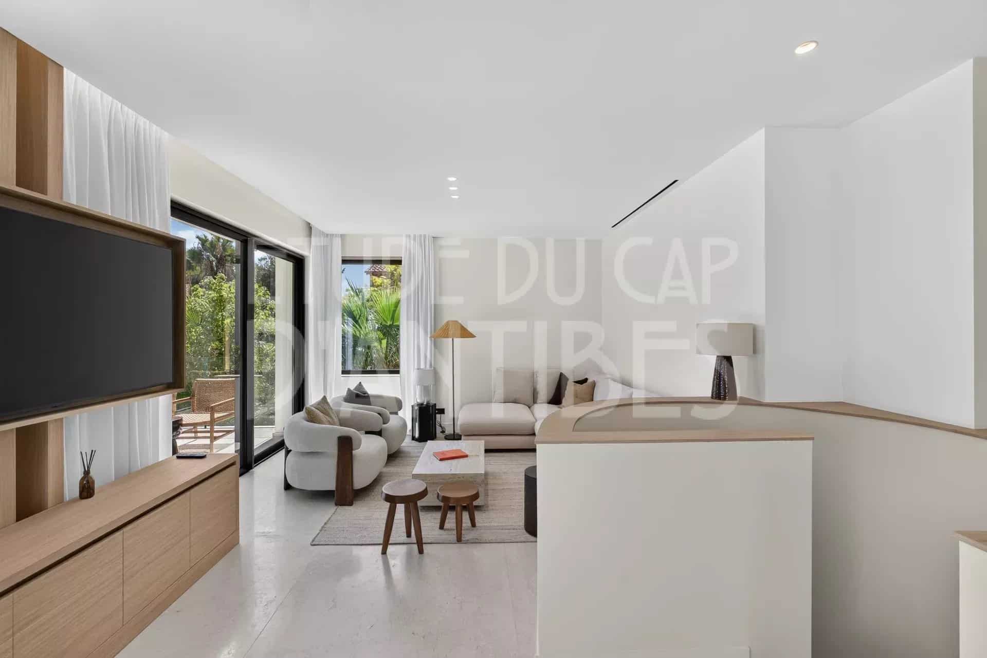 Intérieur d'une villa moderne à Antibes avec salon lumineux et accès à la terrasse.