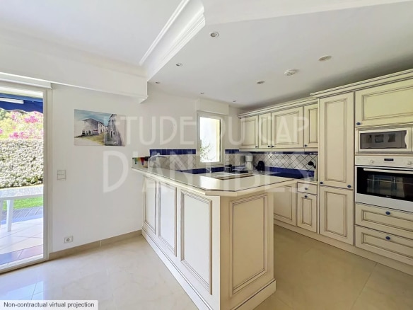 Cuisine moderne et spacieuse d'un appartement à Antibes, avec meubles en bois clair et plan de travail en marbre.