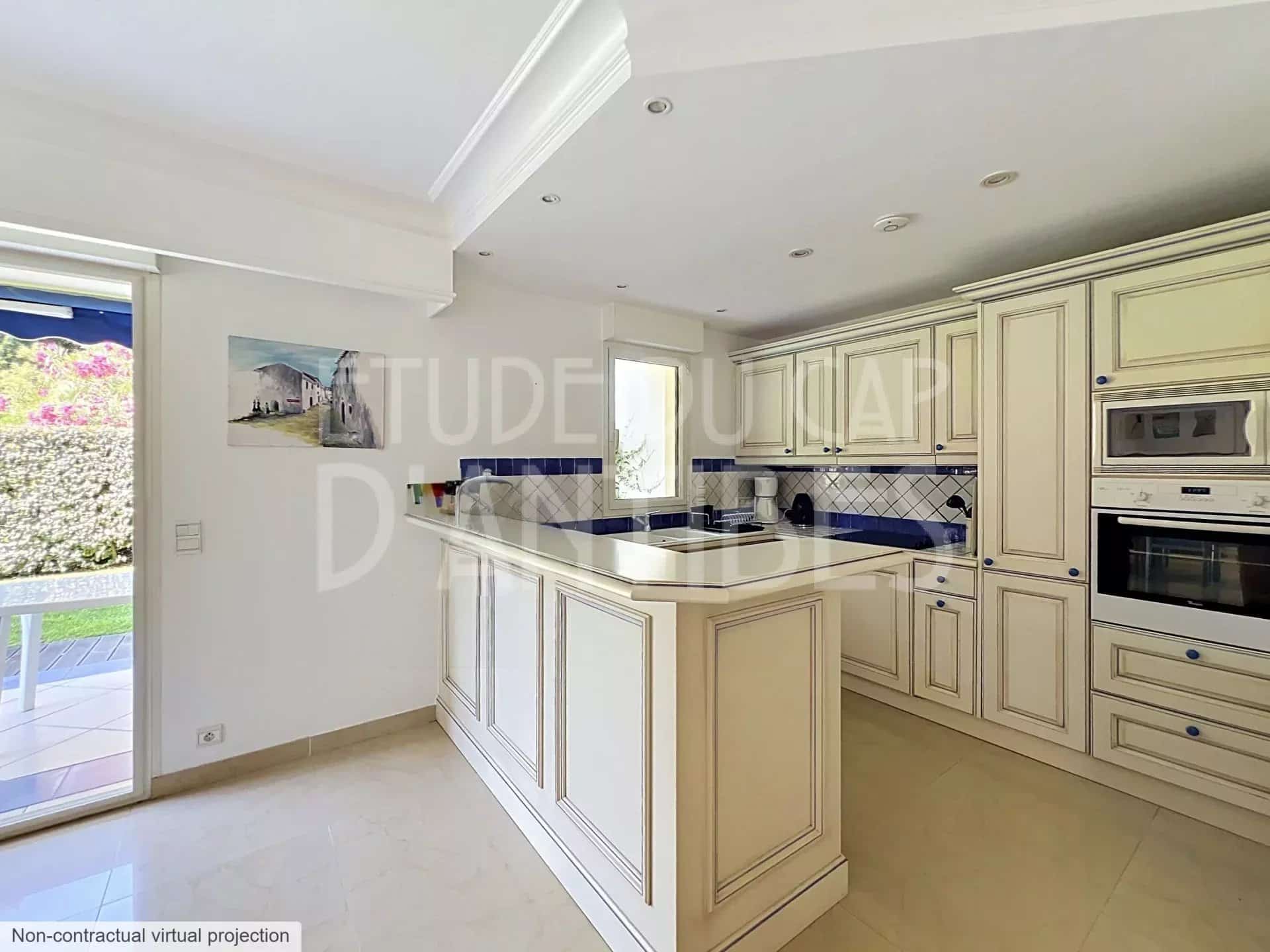 Cuisine moderne et spacieuse d'un appartement à Antibes, avec meubles en bois clair et plan de travail en marbre.