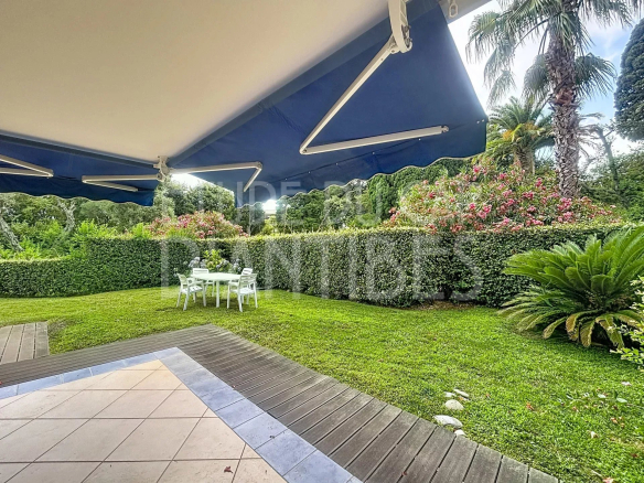 Jardin privatif d'un appartement avec mobilier de jardin, entouré de verdure.
