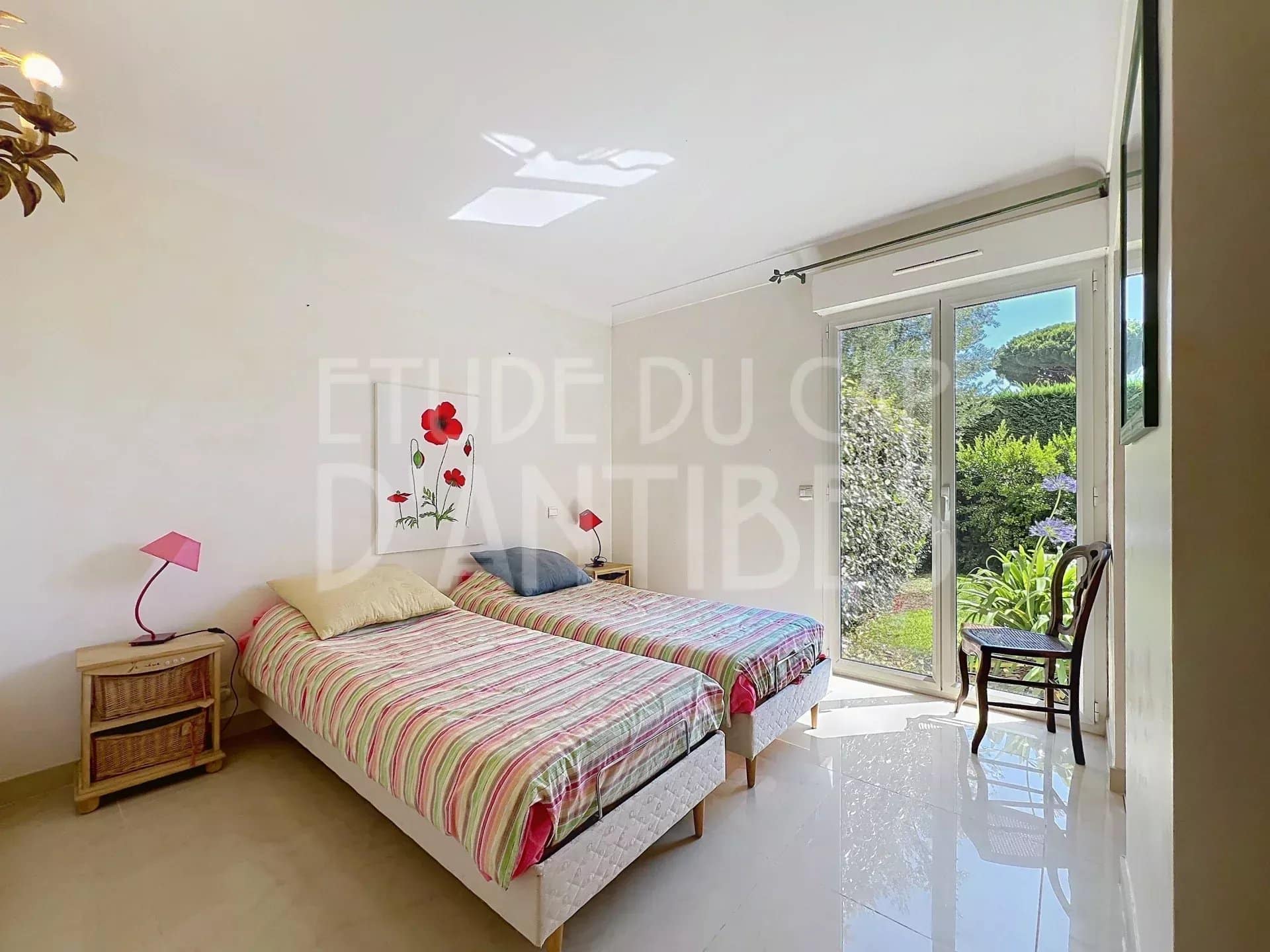 Chambre avec deux lits simples et accès à un jardin privatif dans un appartement à Antibes.