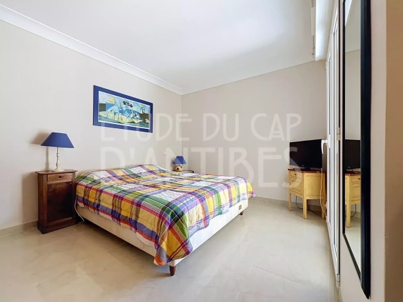 Chambre d'un appartement avec lit double, bureau et télévision.