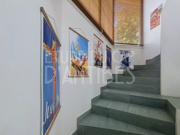 Escalier lumineux avec affiches décoratives à Antibes.