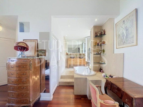 Salle de bain moderne avec baignoire et meuble en bois, décorée avec des objets d'art.