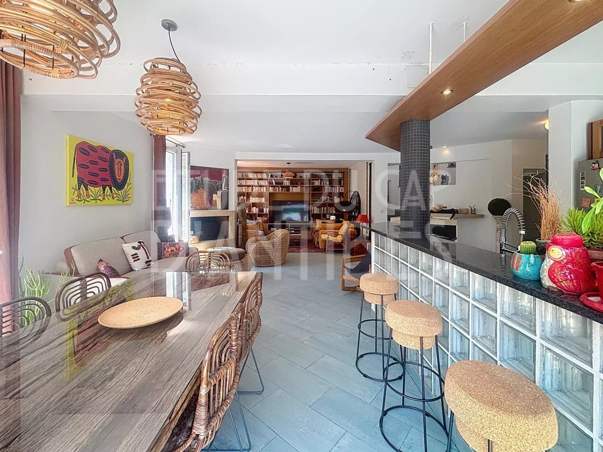 Intérieur d'une villa méditerranéenne à Antibes avec salon, salle à manger et cuisine ouverte.