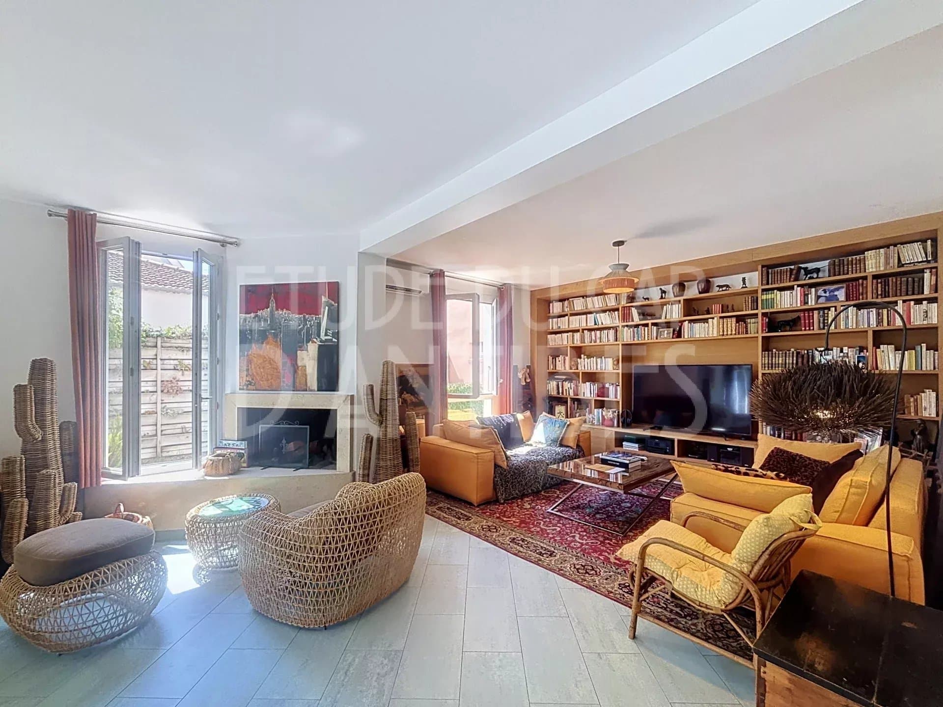 Intérieur d'une villa méditerranéenne à Antibes avec salon lumineux et bibliothèque.