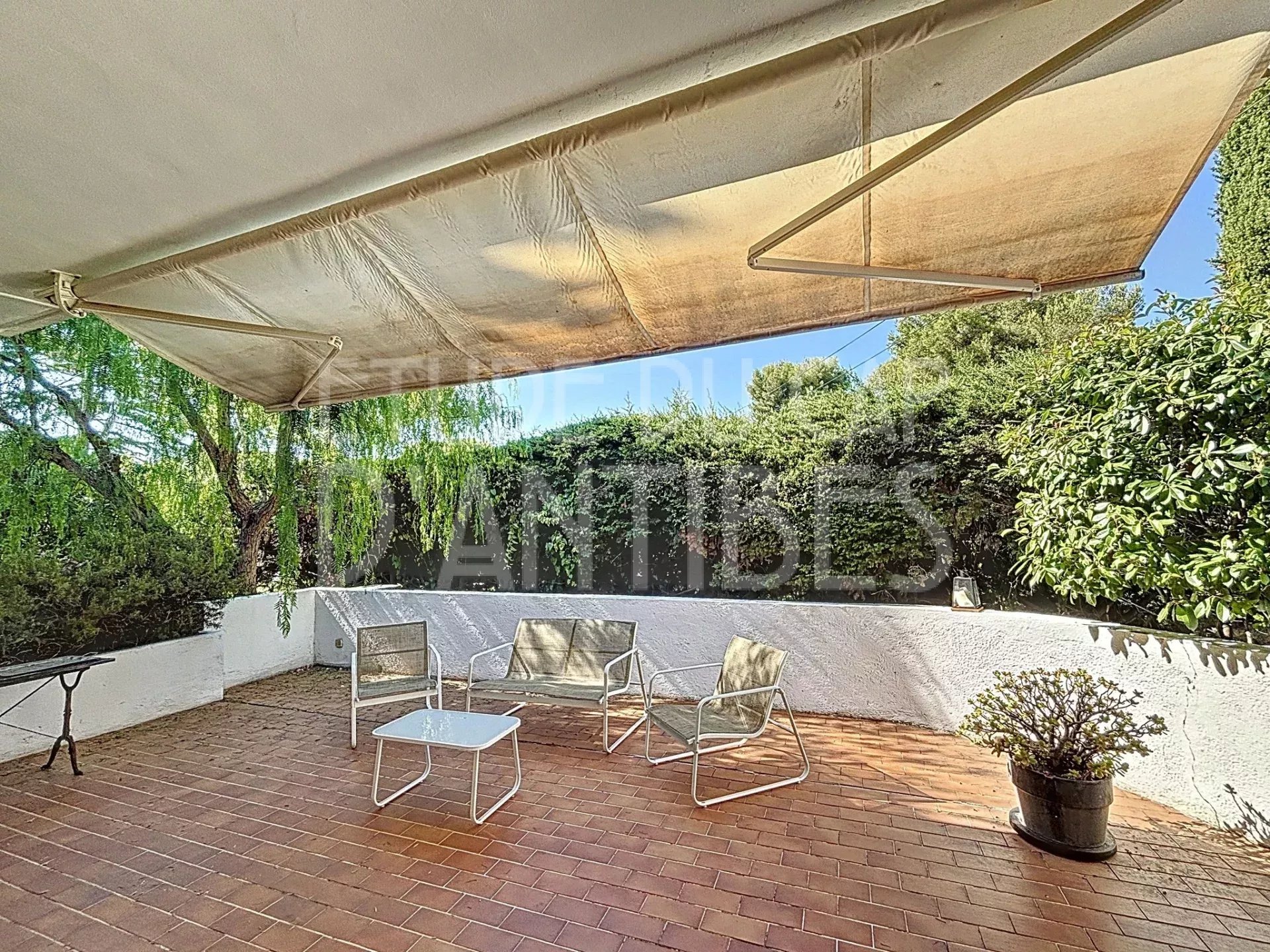 Terrace of a Californian villa in Antibes Shaded terrace of a Californian villa in Antibes with garden furniture.