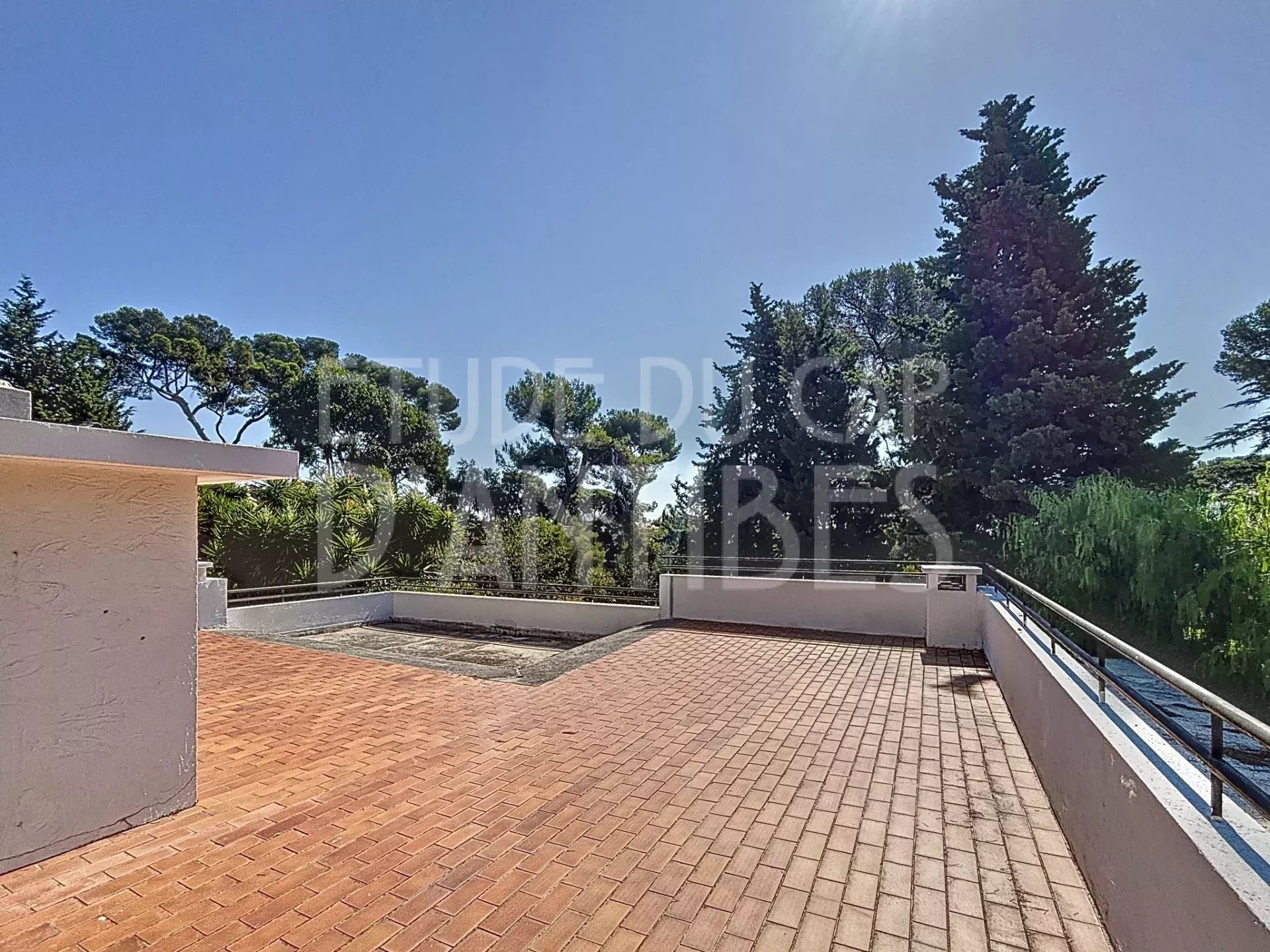 Terrace of the Californian villa at Cap d'Antibes Sunny terrace of a Californian villa in Cap d'Antibes, with unobstructed views of the garden.