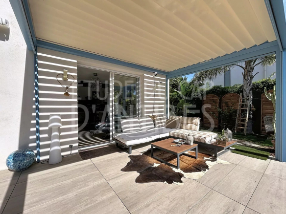 Terrasse d'une villa à Cap d'Antibes avec mobilier de jardin et vue sur la verdure.
