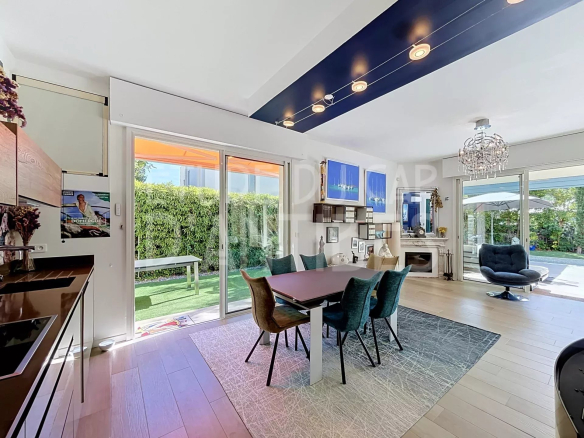 Intérieur d'une villa moderne avec salle à manger et accès à un jardin, Cap d'Antibes.