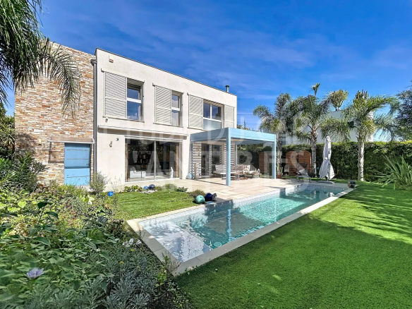 Villa moderne avec piscine et jardin, Cap d'Antibes, vue dégagée sur la verdure.