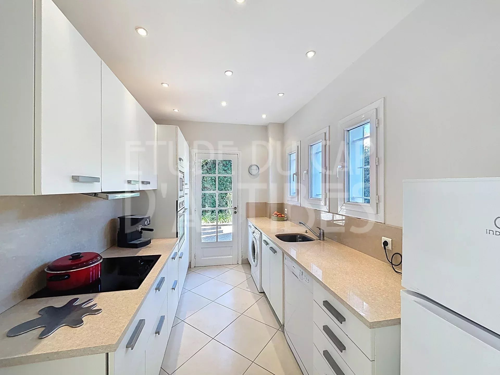 Kitchen of the villa in Antibes Modern kitchen with windows and access to the outside in a villa in Antibes.