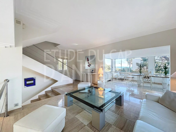 Interior of a modern villa with a bright living room and access to a terrace.