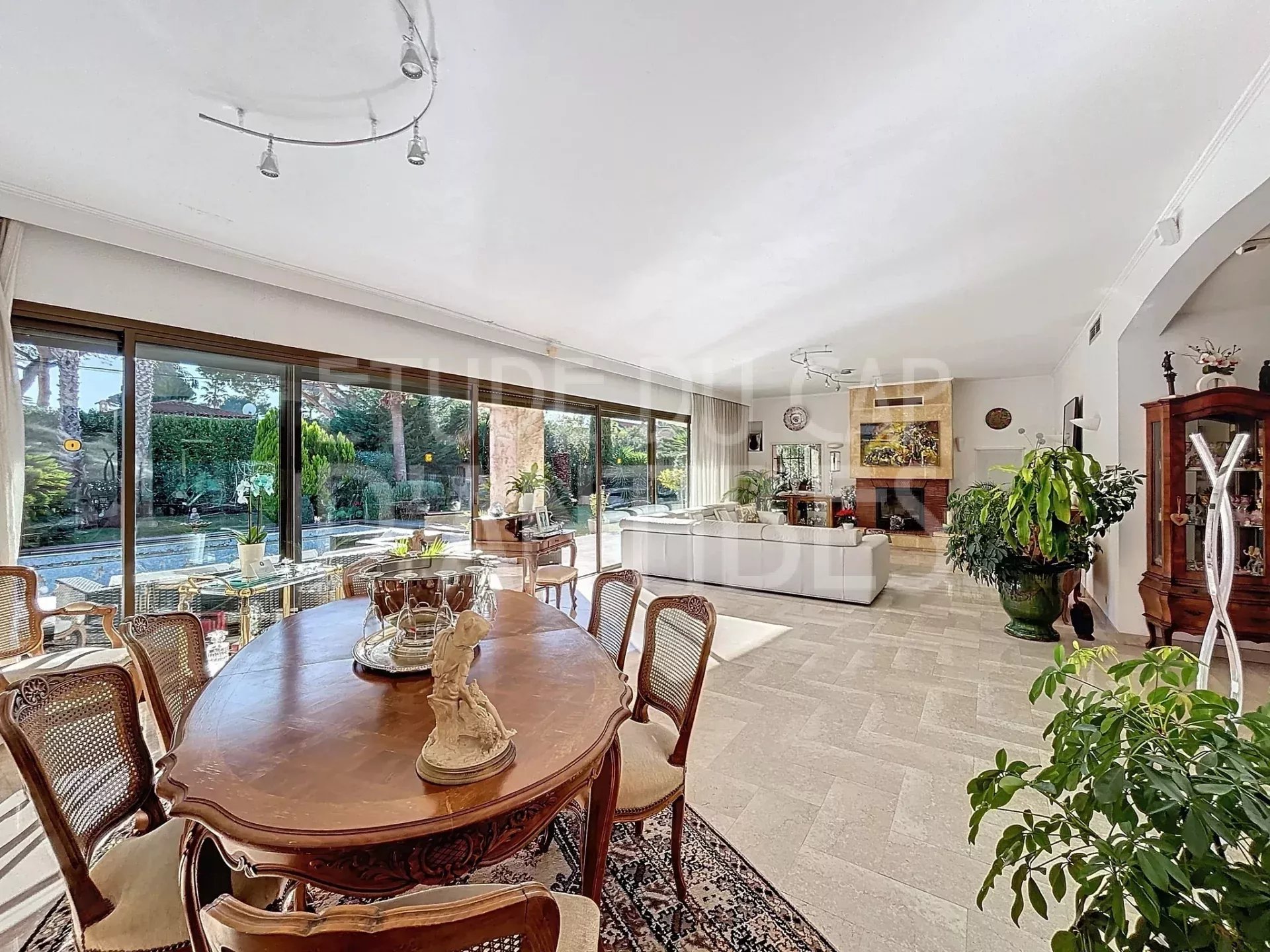 Intérieur d’une villa à Antibes Intérieur d'une villa lumineuse avec salle à manger et salon, grandes baies vitrées donnant sur le jardin.