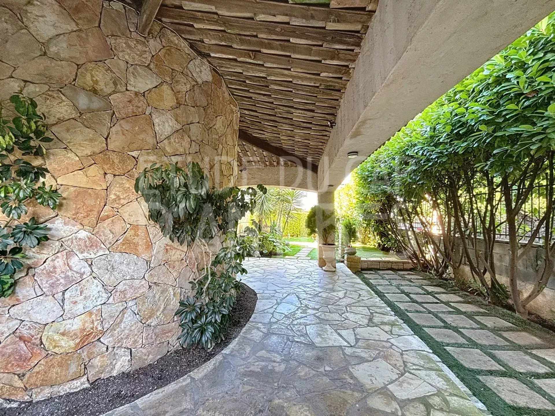 Allée de villa à Cap d’Antibes Allée d'une villa avec murs en pierre et végétation, Cap d'Antibes.