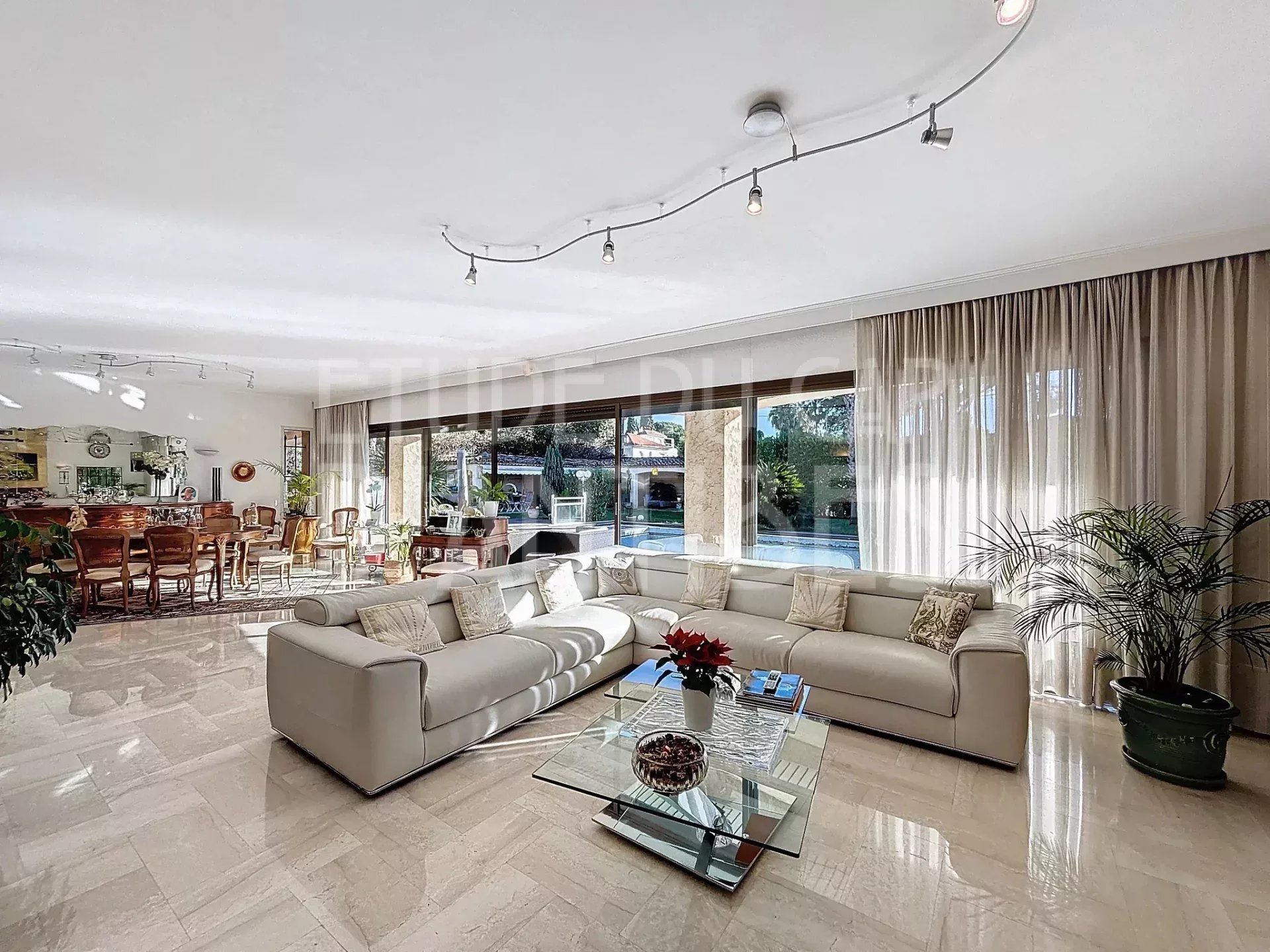 Intérieur de villa à Cap d’Antibes Intérieur lumineux d'une villa avec salon spacieux et accès à la piscine.
