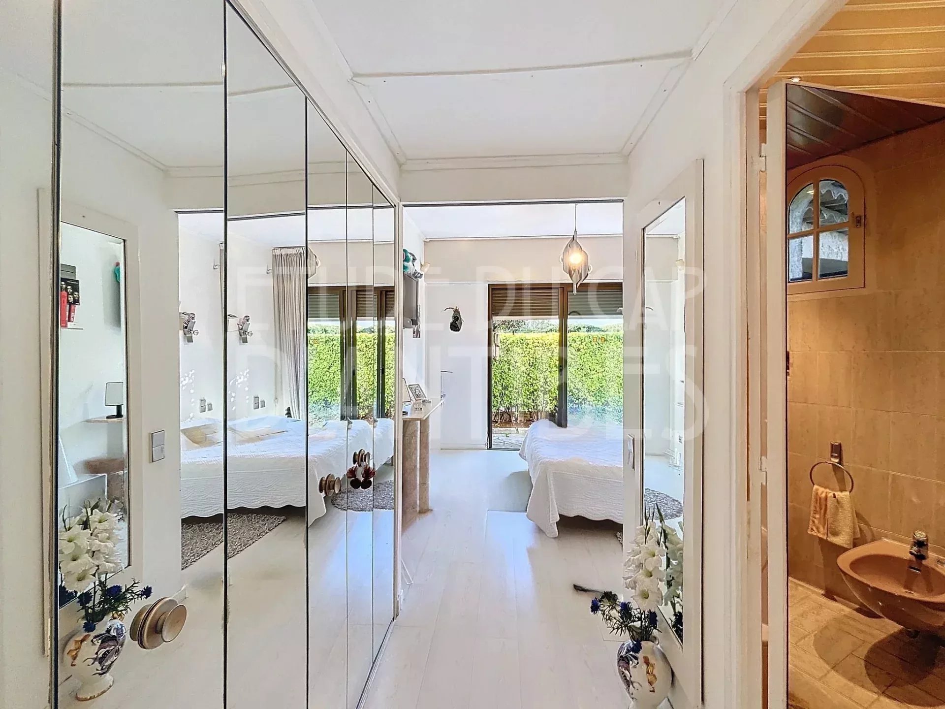 Intérieur d’une villa à Antibes Intérieur d'une villa à Antibes avec deux chambres, miroir et décoration lumineuse.
