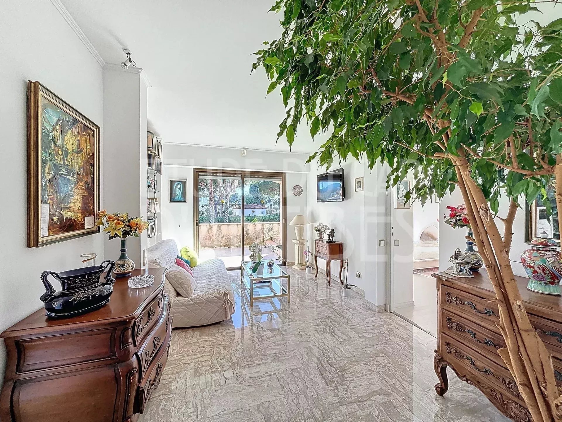 Intérieur de villa à Antibes Intérieur lumineux d'une villa à Antibes avec salon, meubles en bois et vue sur le jardin.