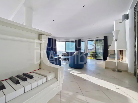 Intérieur d'une villa lumineuse avec un piano, vue sur la mer à Roquebrune-sur-Argens.