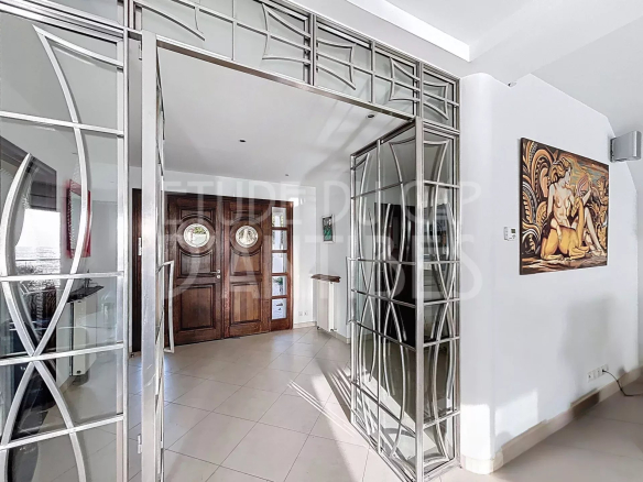 Entrée d'une villa moderne avec des portes en bois et des éléments en verre.