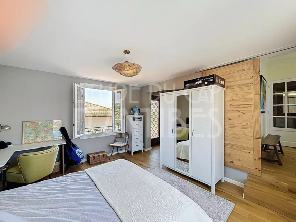 Room in a detached house in Antibes, with bed, wardrobe and desk.
