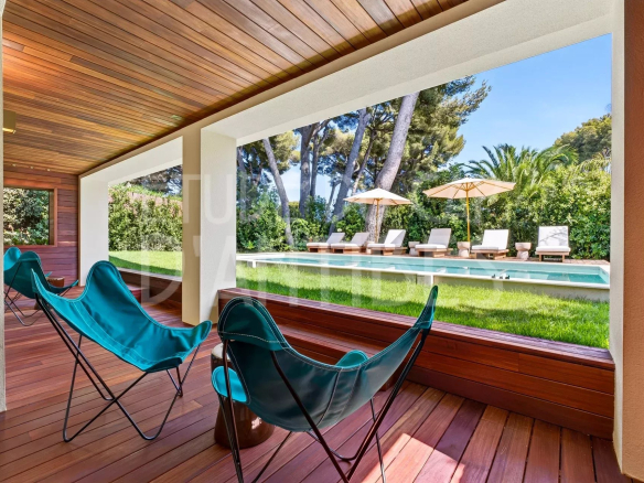 Terrasse d'une villa à Antibes avec vue sur la piscine et le jardin.