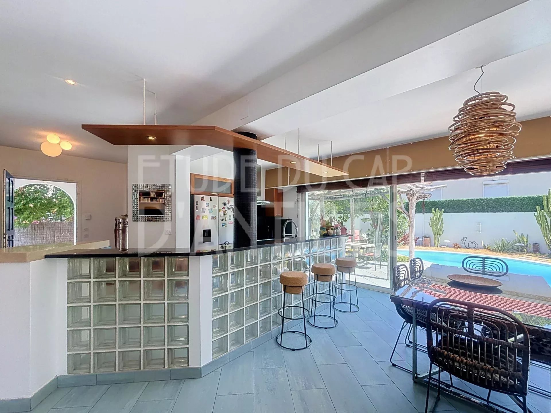 Intérieur de villa méditerranéenne Intérieur d'une villa méditerranéenne avec cuisine ouverte et bar, vue sur la piscine.