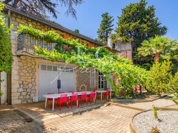 Seaside property with wooded grounds in Cannes, three stone buildings and terrace.