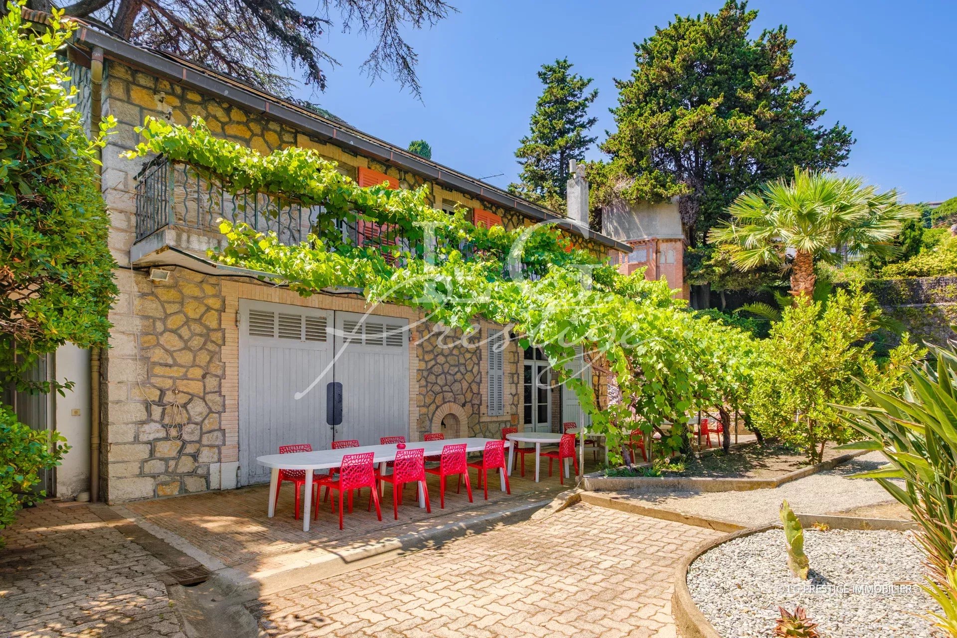 Seaside property with wooded grounds in Cannes, three stone buildings and terrace.