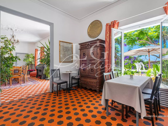 Interior of a property with orange tiles and antique furniture, overlooking the garden.