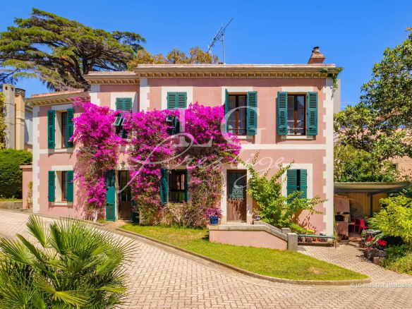 800 m² property with pink facade and flowers, located on the seafront in Cannes.