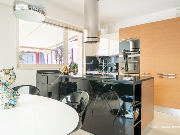 Cuisine moderne d'une villa sur le toit avec îlot central et vue sur la mer à Théoule-sur-Mer.