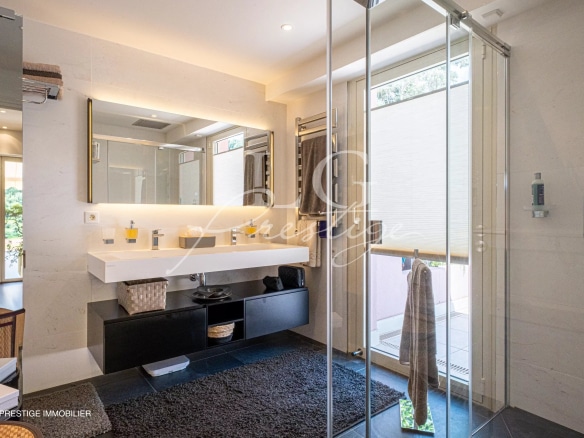 Salle de bain moderne avec douche en verre et lavabo dans une villa sur le toit à Théoule-sur-Mer.