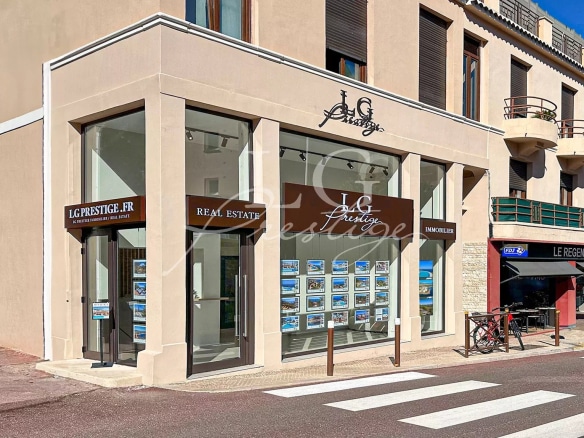 Real estate agency with shop windows displaying advertisements in Théoule-sur-Mer.