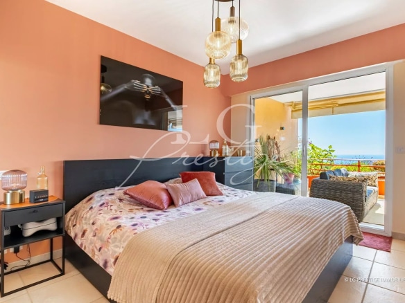 Apartment room with sea view in Mandelieu-la-Napoule, decorated with a bed and modern lighting.