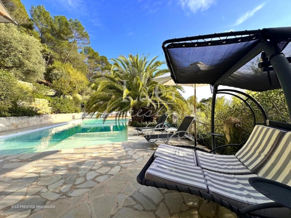 Terrasse avec transats et piscine dans un jardin méditerranéen à Montauroux.