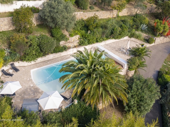 Vue aérienne d'une maison avec piscine entourée de jardin méditerranéen à Montauroux.