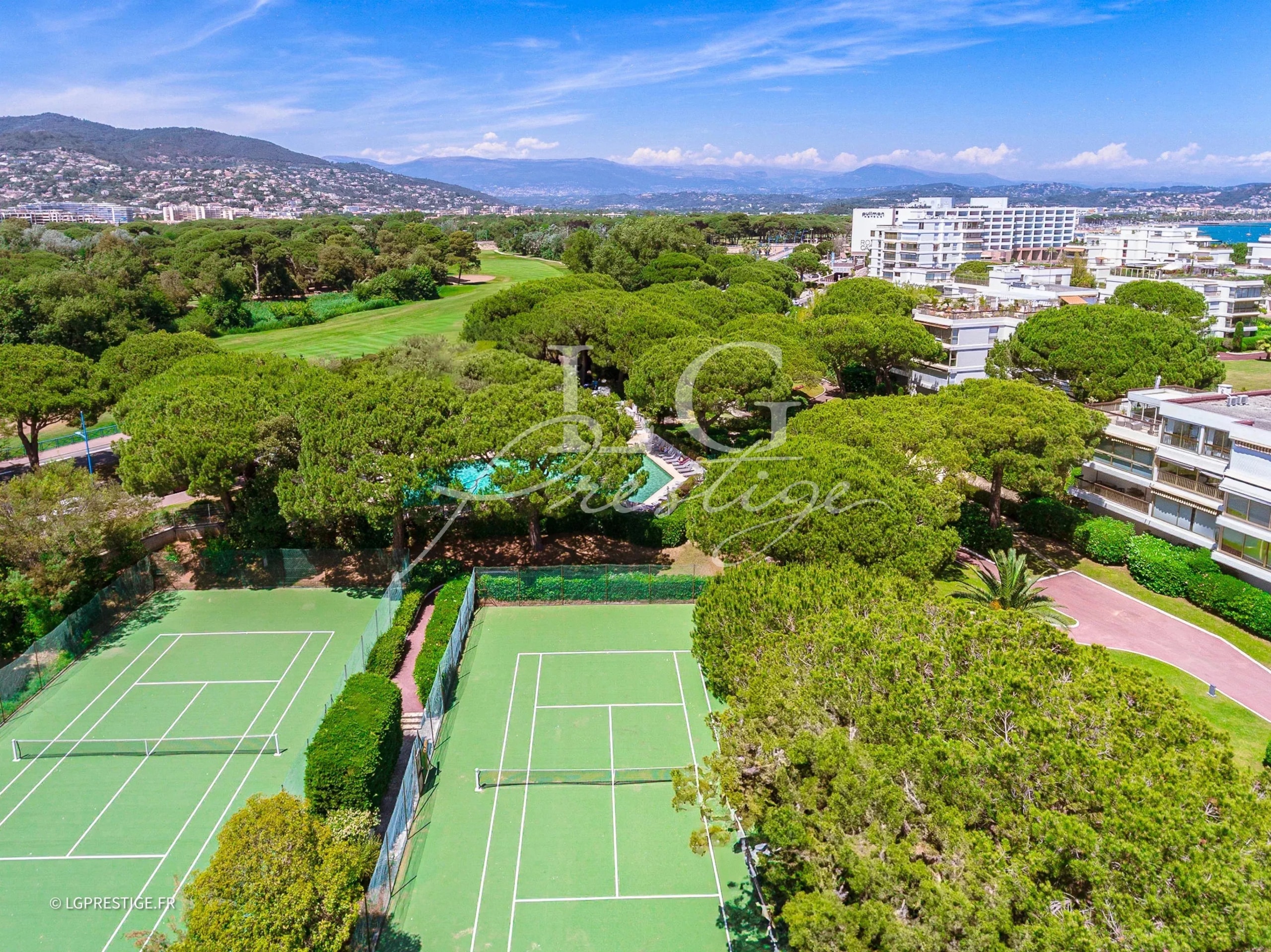Tennis courts in a residence in Mandelieu-la-Napoule Aerial view of the tennis courts and green spaces of a residence in Mandelieu-la-Napoule.