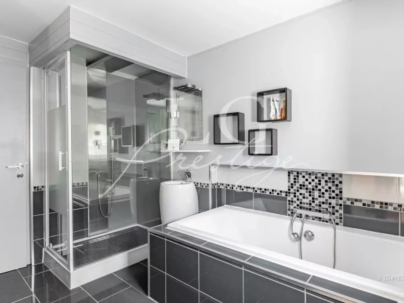 Salle de bain moderne avec baignoire et douche, carrelage noir et blanc