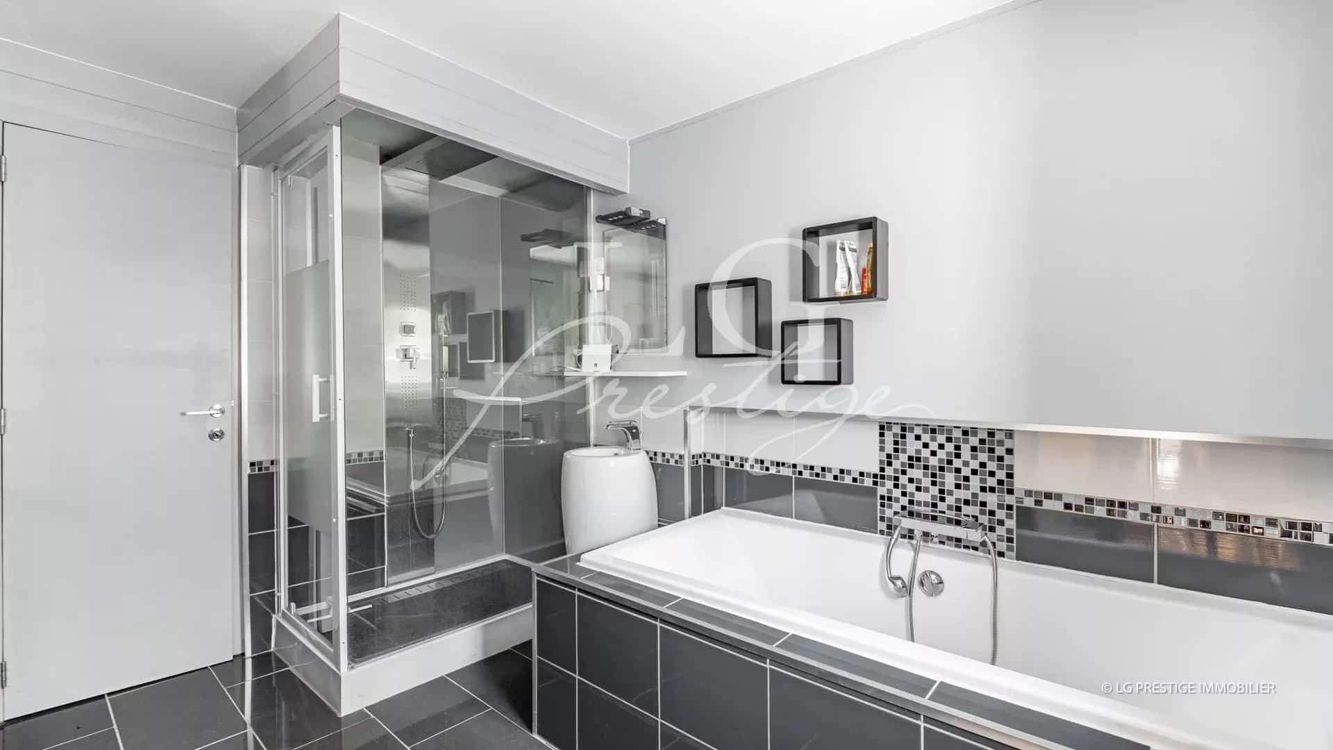 Salle de bain moderne avec baignoire et douche, carrelage noir et blanc