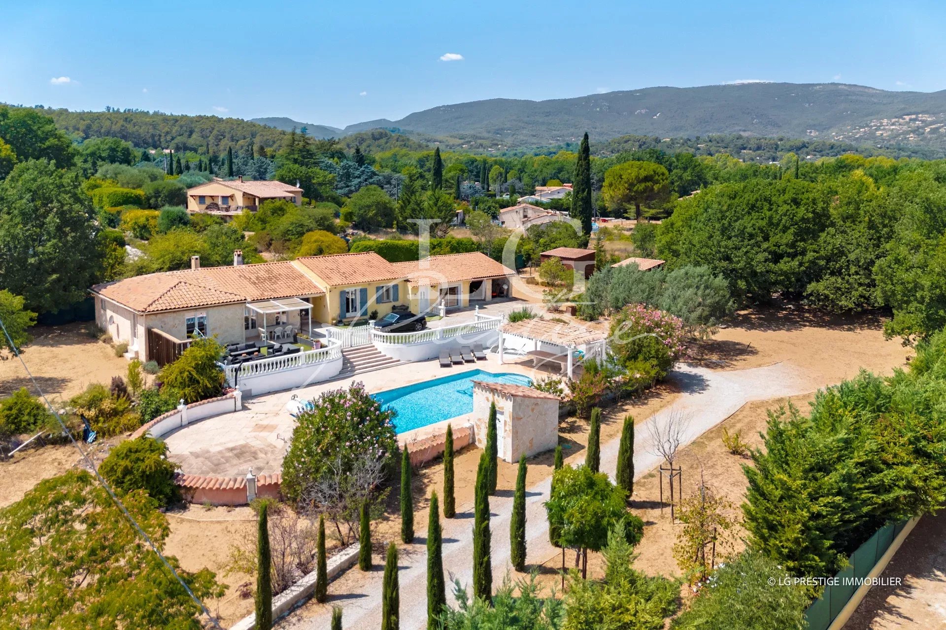 Villa de plain-pied avec piscine sur un terrain de 5 000 m² à Fayence, entourée de verdure.